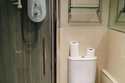 a bathroom with a toilet with two rolls of toilet paper at JOIVY Warm & Welcoming Flat near Edinburgh Castle in Edinburgh