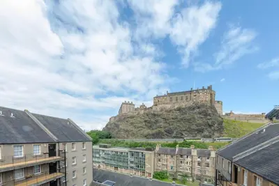 a castle on top of a hill with buildings at JOIVY Warm & Welcoming Flat near Edinburgh Castle in Edinburgh