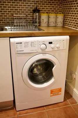 a white washing machine in a kitchen next to a counter at Central Stay on Main st- Harbour Views in Oban