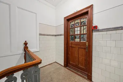 a hallway with a wooden door and a staircase at Panoramic Sea Views - Stunning 3BD Apt & Balcony in Oban
