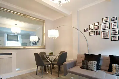 a living room with a couch and a table and a mirror at JOIVY Unique Old Town Stay under Edinburgh Castle in Edinburgh
