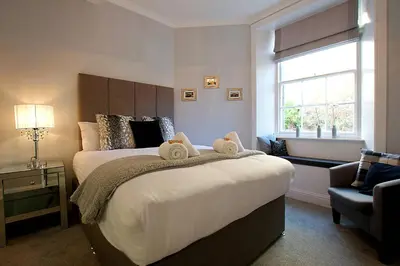 a bedroom with a large bed with towels on it at JOIVY Unique Old Town Stay under Edinburgh Castle in Edinburgh