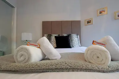a bedroom with a bed with towels on it at JOIVY Unique Old Town Stay under Edinburgh Castle in Edinburgh