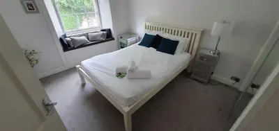a bedroom with a large white bed with blue pillows at JOIVY Unique Old Town Stay under Edinburgh Castle in Edinburgh