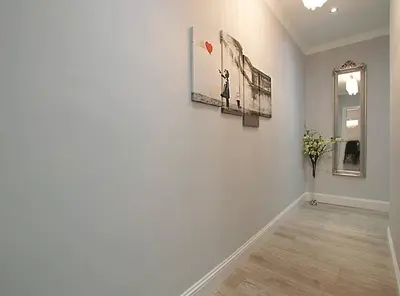 a white hallway with two pictures on the wall at JOIVY Unique Old Town Stay under Edinburgh Castle in Edinburgh