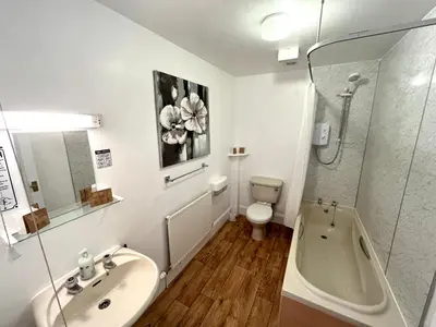 a bathroom with a sink and a tub and a toilet at Buccleuch Arms Hotel in Moffat