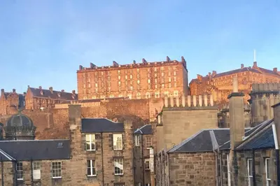 a large brick building in the middle of a city at JOIVY Classic Apt with Castle Views in Old Town in Edinburgh