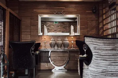 a dining room with a mirror and a table with chairs at Richmond Park Hotel in Boʼness