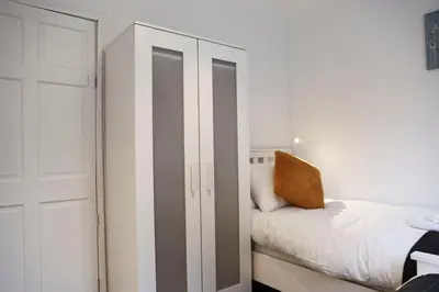 a bedroom with a white closet and a bed at Baron View Apartment in Paisley