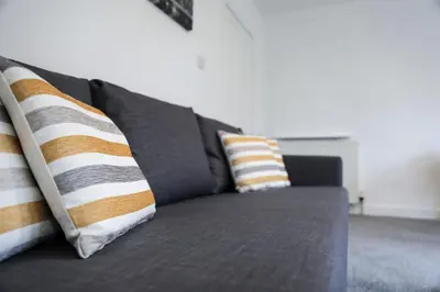 a gray couch with two pillows on it at Baron View Apartment in Paisley