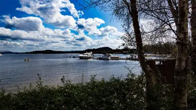 a view of a lake with boats in the water at The Lodge On Loch Lomond Hotel in Luss