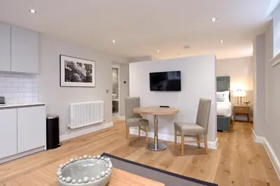 a kitchen and living room with a table and chairs at Destiny Scotland New Town Apartments in Edinburgh