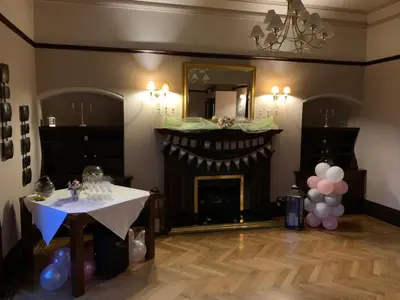 a living room with a fireplace and a table with balloons at Dunmar House Hotel - Bar & Restaurant in Alloa