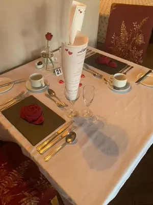 a table with a table set with silverware and a vase at Dunmar House Hotel - Bar & Restaurant in Alloa