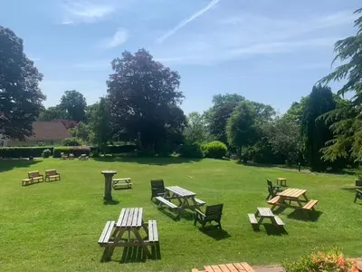 a group of picnic tables and benches in a field at Dunmar House Hotel - Bar & Restaurant in Alloa
