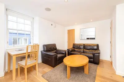 a living room with a couch and a table at JOIVY Superb Flats in the Heart of Edinburgh in Edinburgh