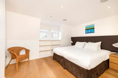 a bedroom with a large bed and a chair at JOIVY Superb Flats in the Heart of Edinburgh in Edinburgh