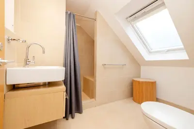 a bathroom with a sink and a skylight at JOIVY Superb Flats in the Heart of Edinburgh in Edinburgh