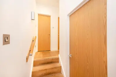 a hallway with a door and a stairway at JOIVY Superb Flats in the Heart of Edinburgh in Edinburgh