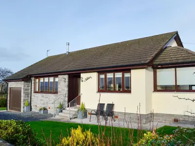 a house with two chairs in front of it at Hillview in Beith
