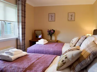 a bedroom with two beds with towels on them at Hillview in Beith