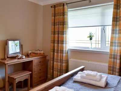 a bedroom with a window and a bed and a dresser at Hillview in Beith