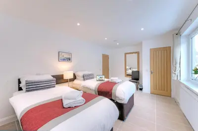 a hotel room with two beds and a window at Beach Houses with Hot Tubs in Glencoe