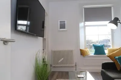 a living room with a couch and a window at Dollar Apartments-39 Bridge Street in Dollar