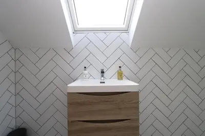a bathroom with a white sink and a window at Dollar Apartments-41 Bridge Street in Dollar