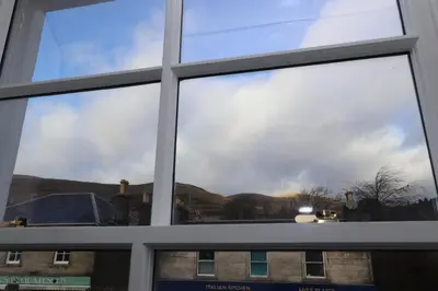 a window in a building with a view of the mountains at Dollar Apartments-41 Bridge Street in Dollar