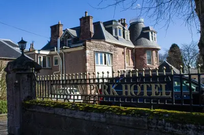 a large house with a black wrought iron fence at The Murray Park Hotel in Crieff