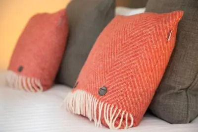 two orange pillows sitting on top of a bed at The Murray Park Hotel in Crieff