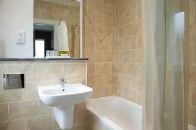 a bathroom with a sink and a bath tub at The Murray Park Hotel in Crieff