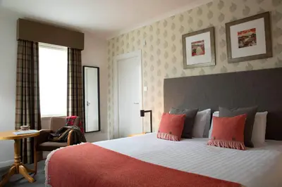 a bedroom with a large bed with a red blanket at The Murray Park Hotel in Crieff