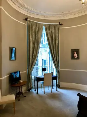 a living room with a table and a window at Escape To Edinburgh @ Albyn Place in Edinburgh