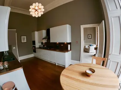a kitchen with a table and a dining room at Escape To Edinburgh @ Albyn Place in Edinburgh