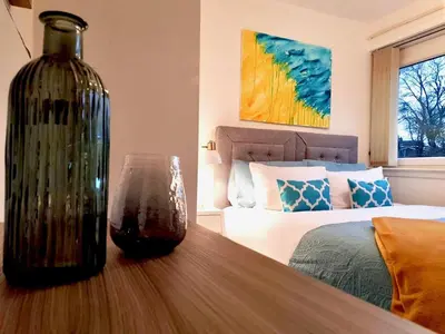 a large vase sitting on a wooden table in a bedroom at South Calder House in Wishaw