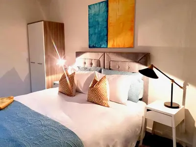 a bedroom with a large white bed with pillows at South Calder House in Wishaw