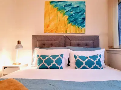 a bedroom with a bed with blue and white pillows at South Calder House in Wishaw