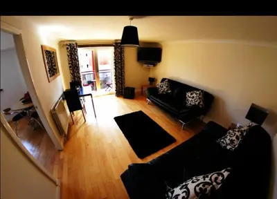 a living room with a couch and a table at Ayr Holiday Apartment Donnini Court in Ayr