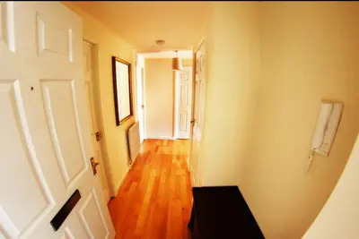 a hallway with a white door and a wooden floor at Ayr Holiday Apartment Donnini Court in Ayr