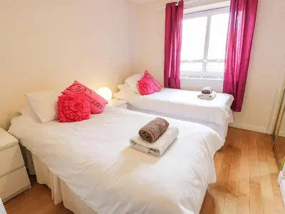 two beds with towels on them in a bedroom at Ayr Holiday Apartment Donnini Court in Ayr