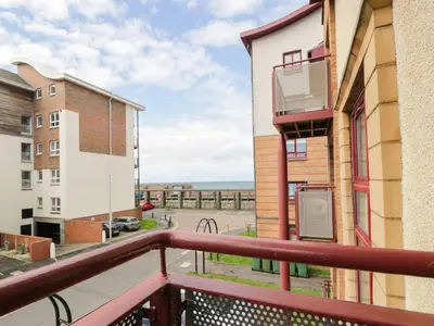 a balcony with a view of a parking lot at Ayr Holiday Apartment Donnini Court in Ayr