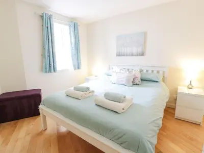 a bedroom with a large bed with towels on it at Ayr Holiday Apartment Donnini Court in Ayr