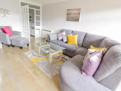 a living room with a couch and a table at Cumbrae View in Largs