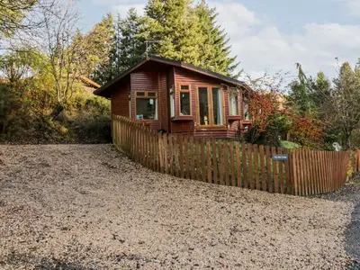 a small wooden house with a fence at The Wee Lodge in Glendevon