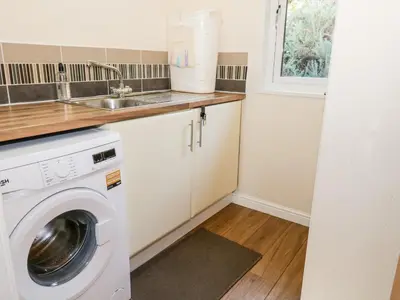 a kitchen with a washing machine and a sink at The Wee Lodge in Glendevon