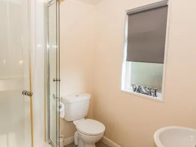 a bathroom with a toilet and a glass shower at The Wee Lodge in Glendevon