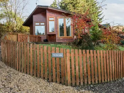 a wooden fence in front of a tiny house at The Wee Lodge in Glendevon
