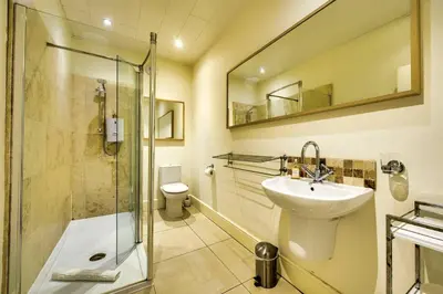a bathroom with a glass shower and a sink at JOIVY Bright 1 bed flat, close to Princess Street in Edinburgh